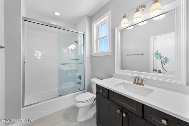 bathroom featuring shower / bath combination with glass door, vanity, and toilet