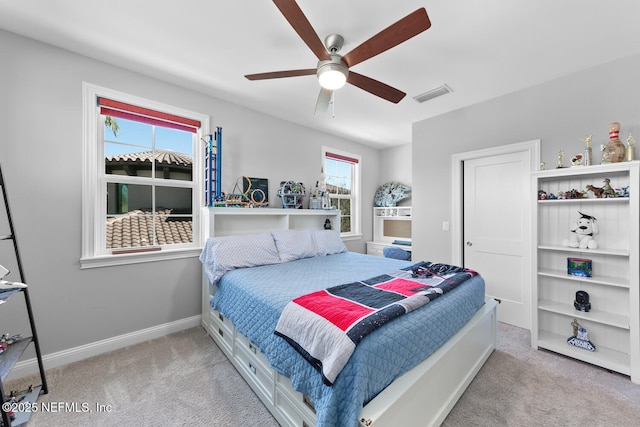 carpeted bedroom featuring ceiling fan, visible vents, and baseboards