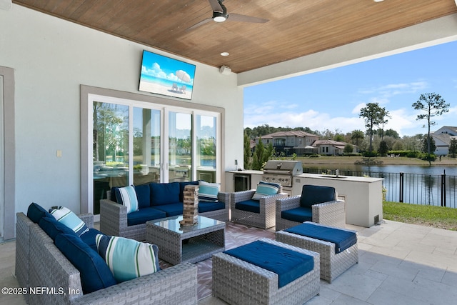 view of patio featuring a grill, fence, an outdoor hangout area, and exterior kitchen