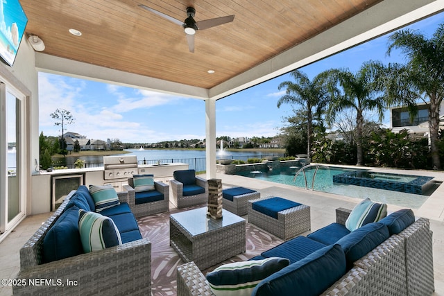 view of patio featuring a pool with connected hot tub, a water view, grilling area, exterior kitchen, and an outdoor living space