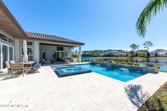 view of swimming pool with a patio, a pool with connected hot tub, a water view, and an outdoor living space