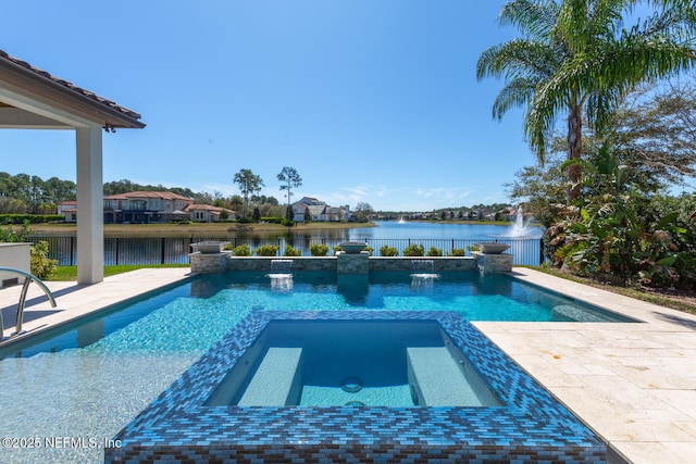 view of pool with a water view, a patio area, a pool with connected hot tub, and fence