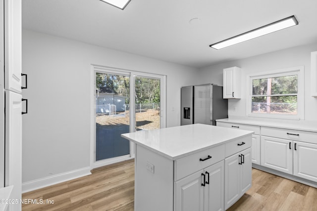 kitchen featuring light wood finished floors, plenty of natural light, light countertops, and stainless steel fridge with ice dispenser