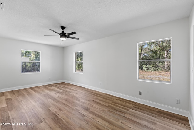 empty room featuring a ceiling fan, a textured ceiling, baseboards, and wood finished floors