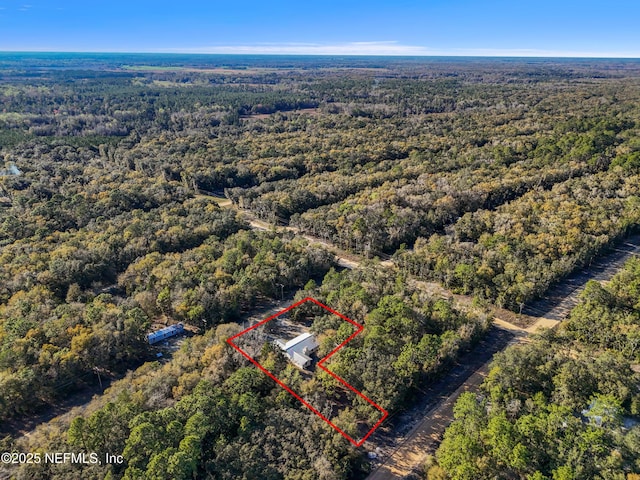 birds eye view of property featuring a forest view