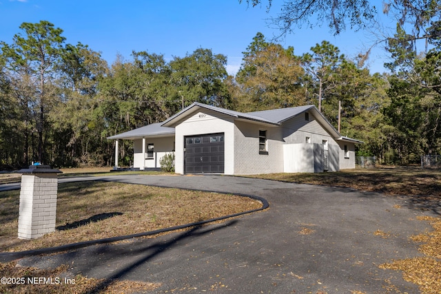 exterior space featuring a garage, driveway, and brick siding