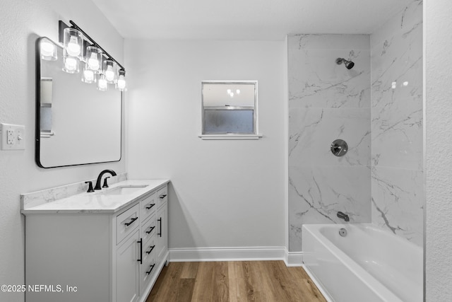 bathroom featuring shower / bath combination, wood finished floors, vanity, and baseboards