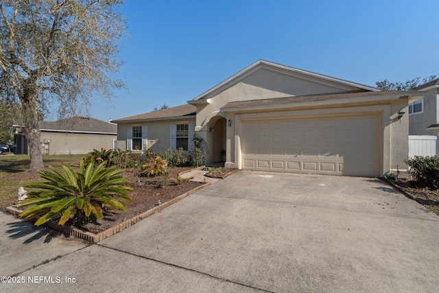 ranch-style home with a garage, concrete driveway, and stucco siding