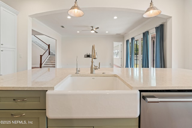 kitchen featuring crown molding, a sink, stainless steel dishwasher, light stone countertops, and pendant lighting