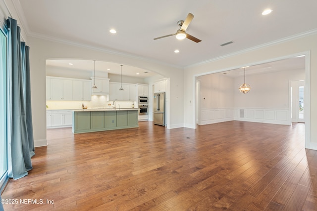 unfurnished living room with light wood finished floors, visible vents, ceiling fan, crown molding, and recessed lighting