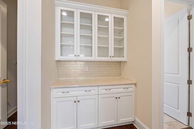 bar featuring baseboards and backsplash