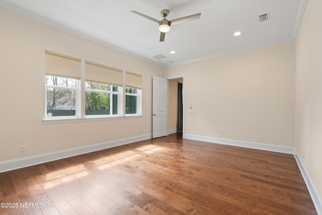 empty room featuring ceiling fan, crown molding, baseboards, and wood finished floors