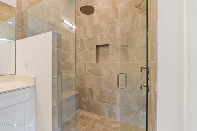 bathroom with a shower stall and vanity