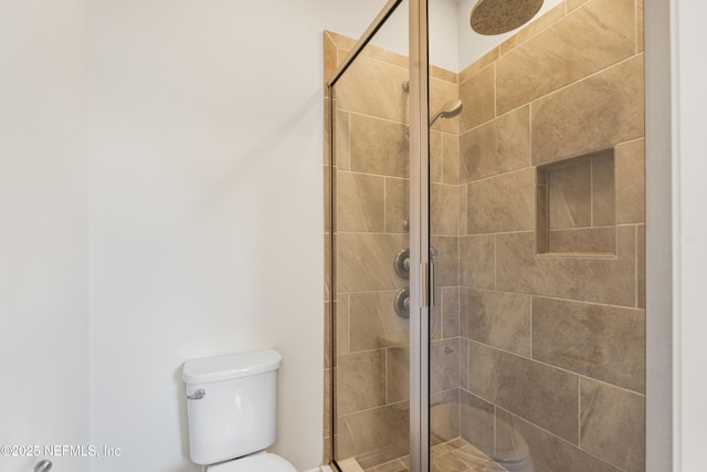 full bath featuring a stall shower and toilet