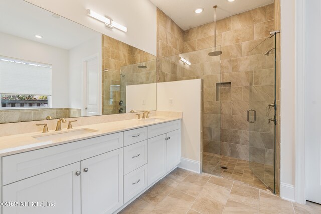 full bath featuring a sink, a shower stall, and double vanity