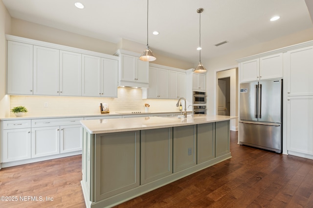 kitchen featuring white cabinetry, stainless steel appliances, dark wood-type flooring, and light countertops