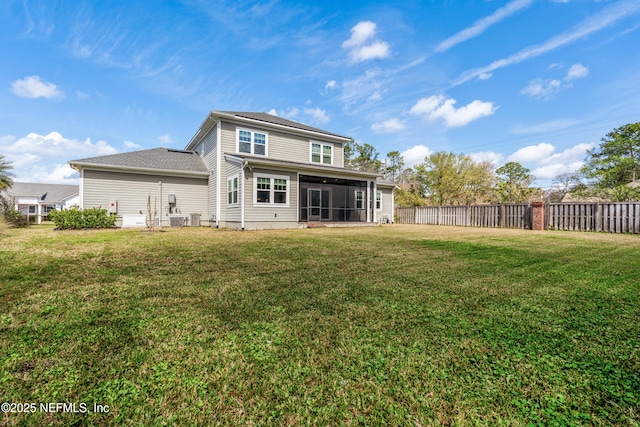 back of property with central AC unit, a sunroom, fence, and a lawn