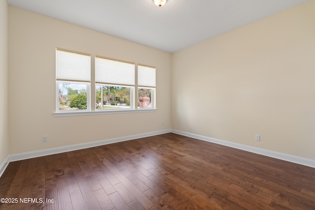 unfurnished room featuring dark wood finished floors and baseboards