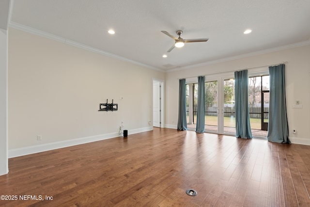 empty room featuring baseboards, wood finished floors, and crown molding