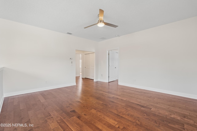 unfurnished room featuring baseboards, visible vents, ceiling fan, and wood finished floors