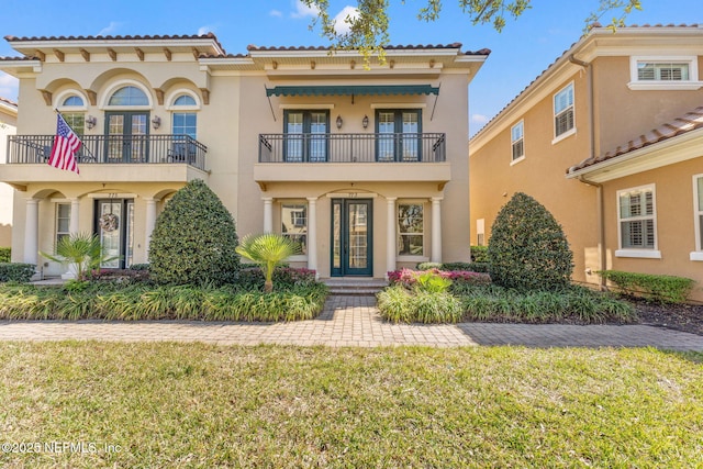 mediterranean / spanish home with a front lawn and stucco siding