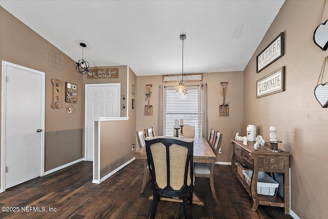 dining area featuring lofted ceiling, dark wood-style flooring, a textured ceiling, and baseboards