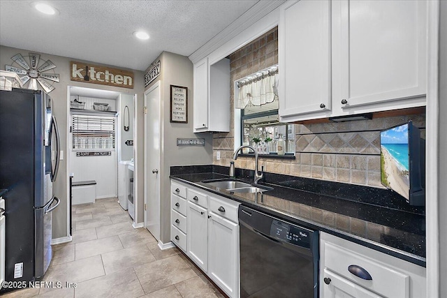 kitchen with black dishwasher, white cabinets, freestanding refrigerator, a sink, and backsplash