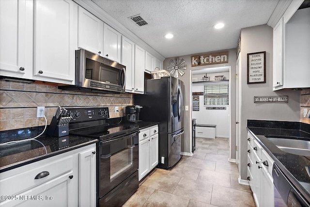 kitchen featuring white cabinets, a sink, a textured ceiling, dark stone countertops, and black appliances