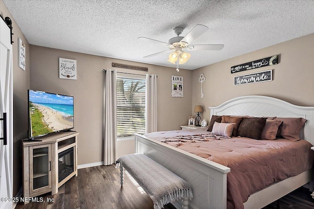 bedroom featuring a textured ceiling, dark wood-type flooring, a ceiling fan, and baseboards