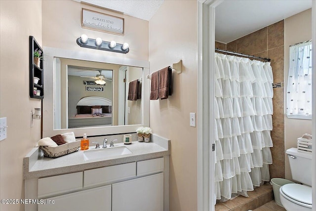 bathroom with toilet, a ceiling fan, a shower with shower curtain, and vanity