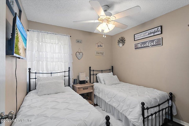 bedroom with a ceiling fan and a textured ceiling