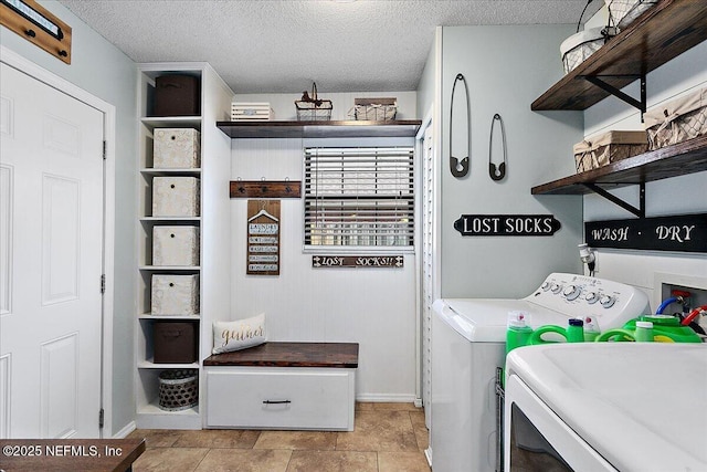 laundry area featuring washing machine and dryer, laundry area, and a textured ceiling