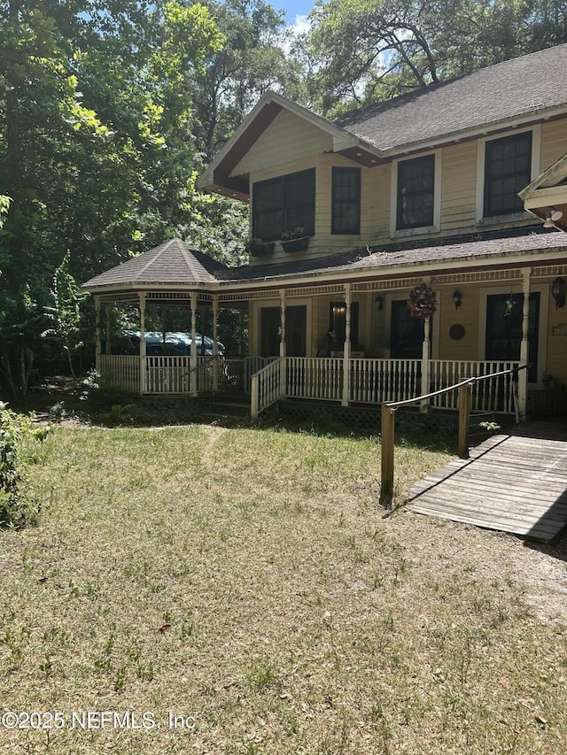 view of front of home with a porch and a front yard