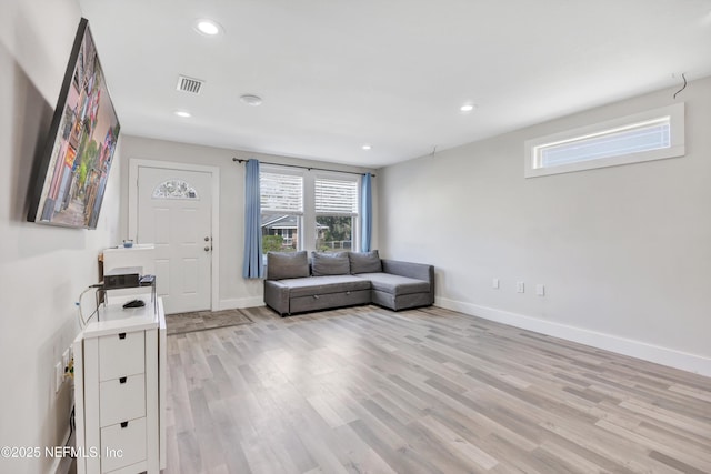 unfurnished living room with light wood finished floors, visible vents, recessed lighting, and baseboards