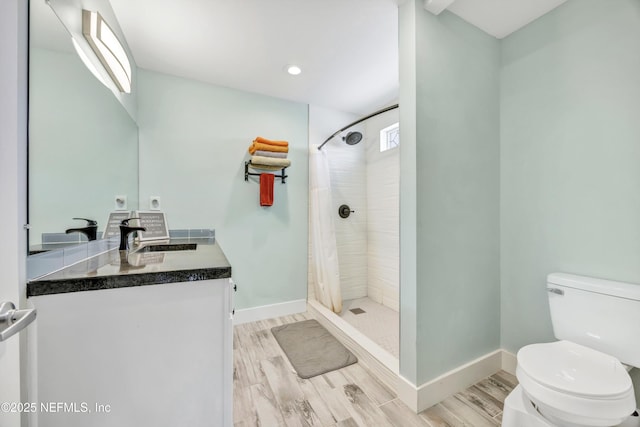 bathroom featuring toilet, a tile shower, and wood tiled floor