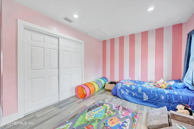 bedroom with visible vents, recessed lighting, attic access, and wood finished floors