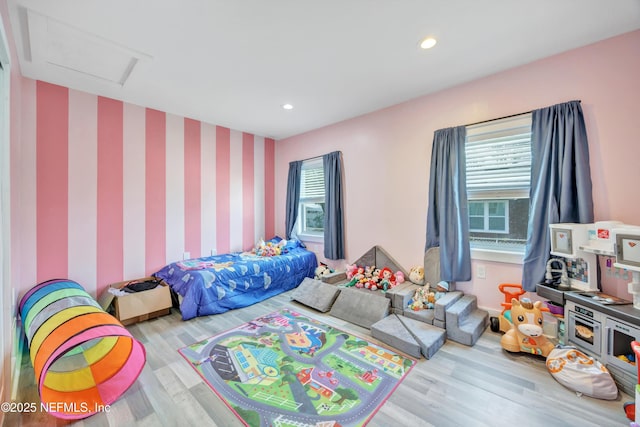 bedroom with recessed lighting, attic access, and wood finished floors