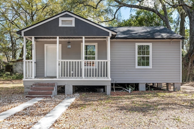 view of front facade with covered porch and roof with shingles