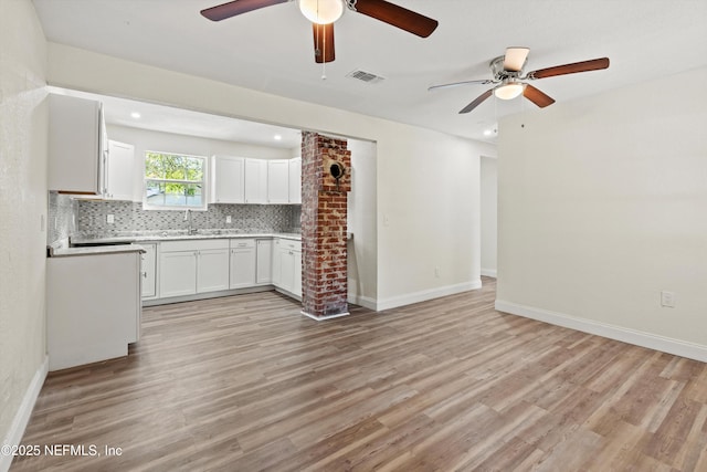 kitchen with visible vents, tasteful backsplash, light wood-style floors, and ceiling fan
