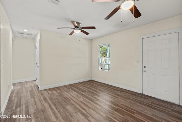 interior space featuring visible vents, ceiling fan, baseboards, and wood finished floors