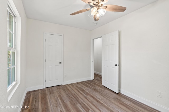 unfurnished bedroom with ceiling fan, baseboards, and wood finished floors