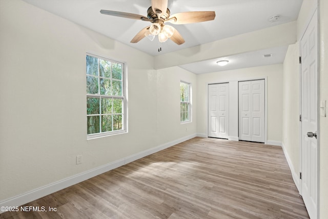 unfurnished bedroom with light wood-style flooring, baseboards, a closet, and ceiling fan