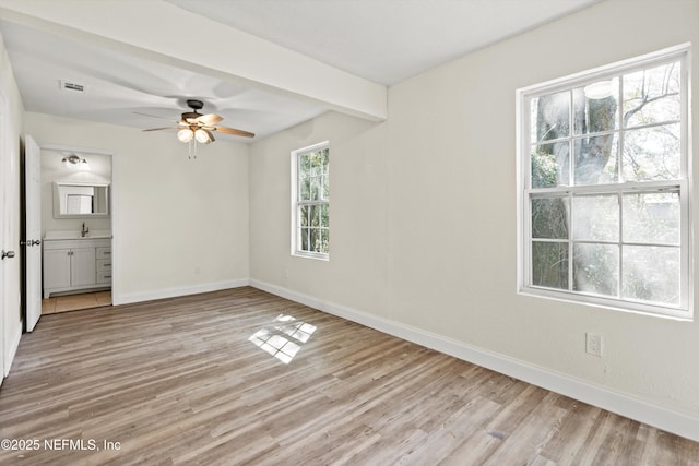 spare room featuring a ceiling fan, light wood-type flooring, baseboards, and a sink