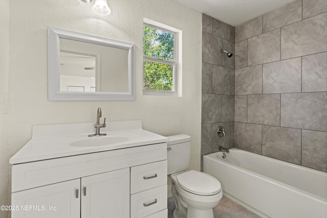 full bath featuring toilet,  shower combination, vanity, and a textured wall