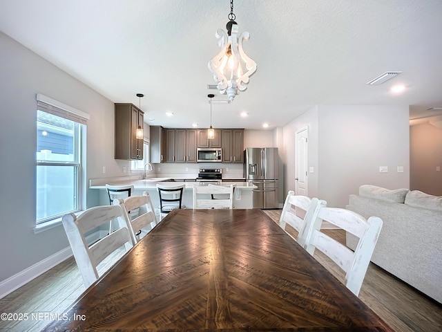 dining space with light wood-style flooring, visible vents, baseboards, and recessed lighting