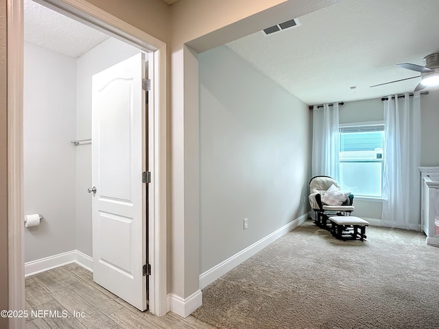 unfurnished room with a ceiling fan, visible vents, baseboards, and a textured ceiling