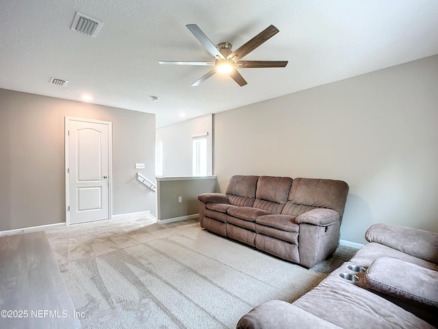 carpeted living room featuring a ceiling fan, visible vents, and baseboards