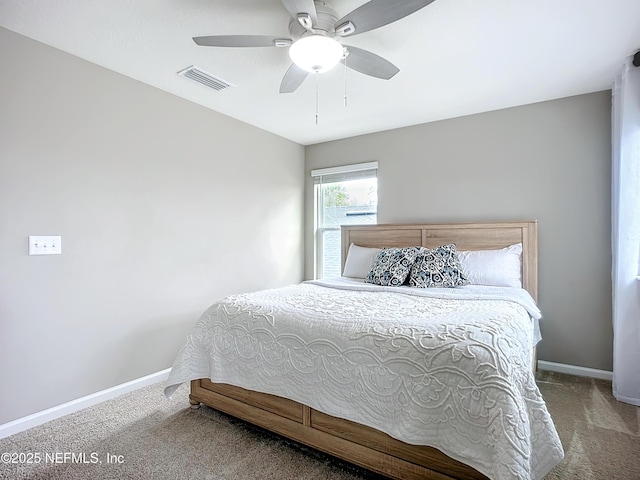 carpeted bedroom featuring a ceiling fan, visible vents, and baseboards