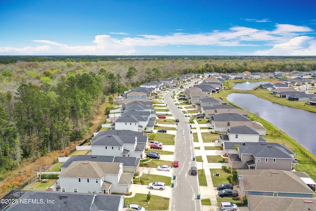 aerial view featuring a residential view, a water view, and a wooded view