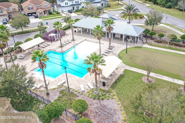 community pool with a residential view, a patio, and fence